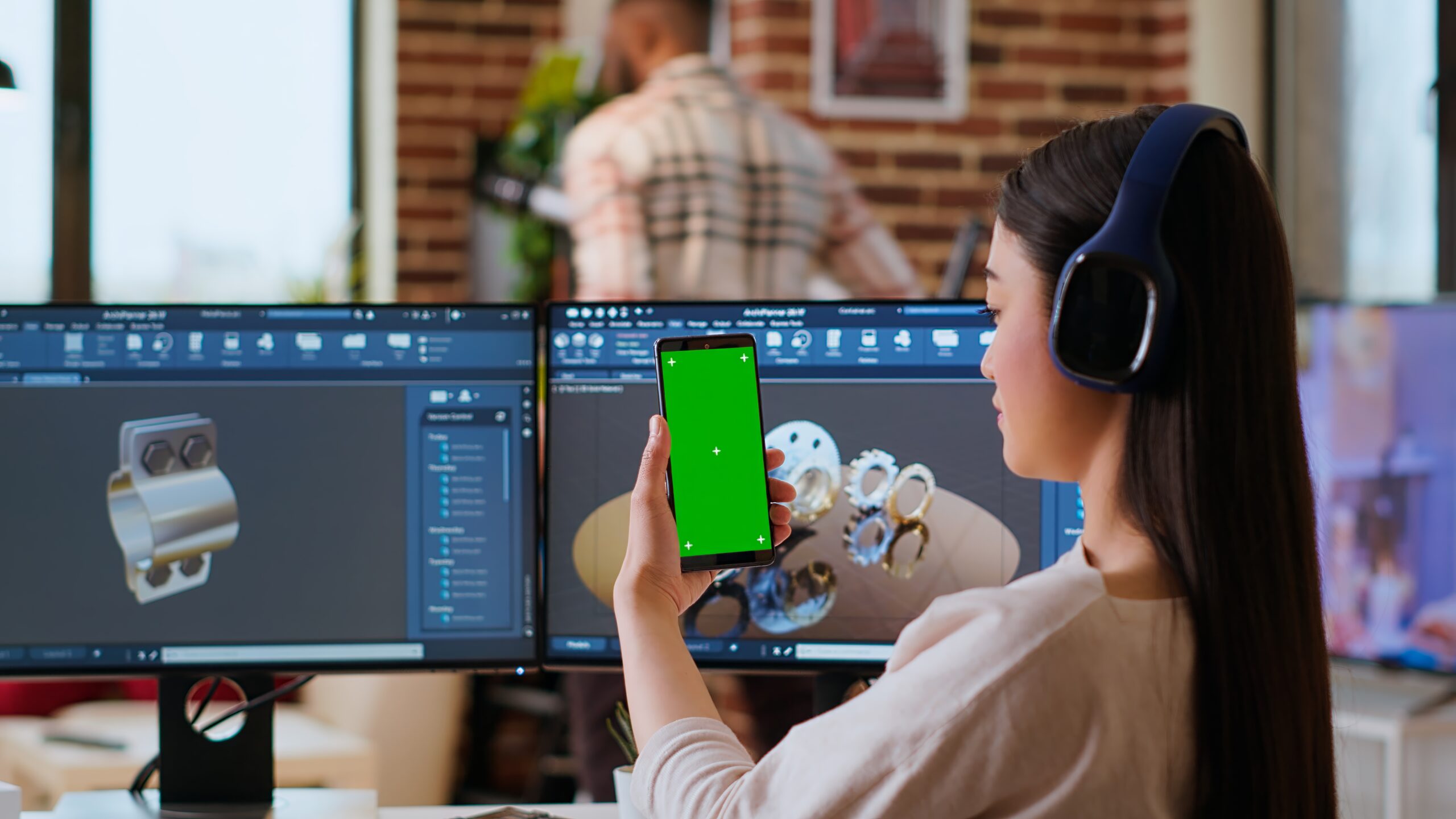Asian freelancer developer working with headphones and chroma key screen, creating a new prototype for manufacturing industry. Female 3D modeling engineer at her home office. Camera B.